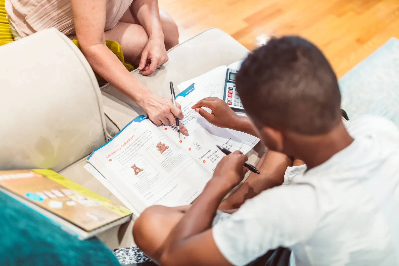 A parent and child working through homework together at home
